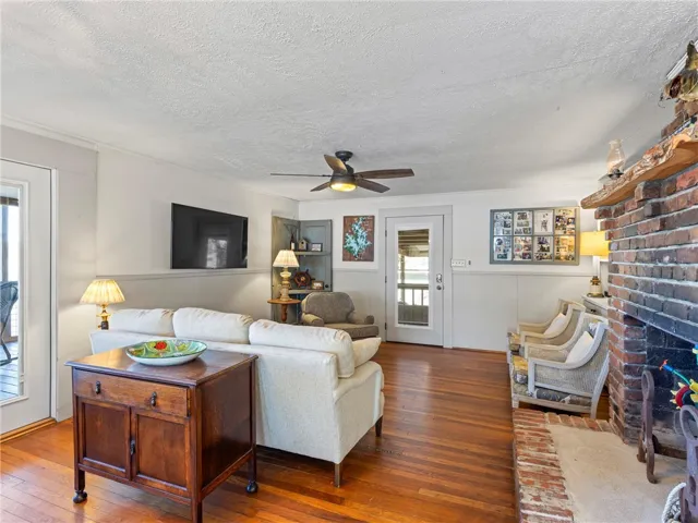 Hardwood floors and a brick fireplace create a cozy living space perfect for gatherings.