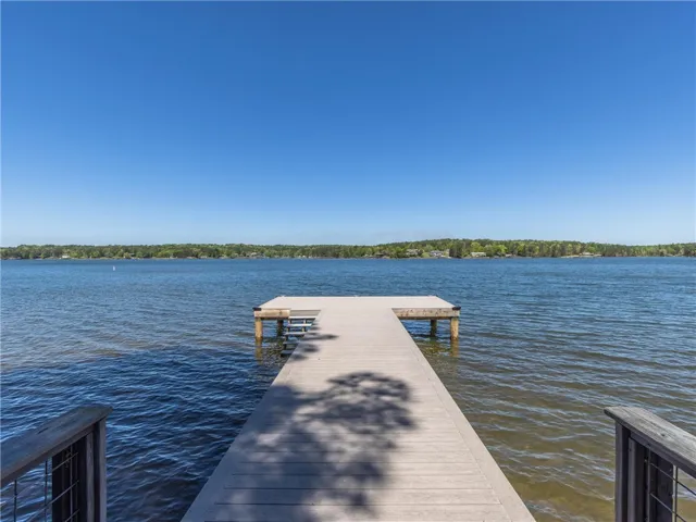 A private boat dock extends into the tranquil lake, offering serene water access and scenic views.