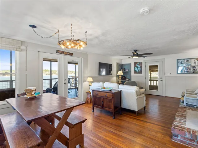 Lakeside living unfolds with rich wood floors and multiple outdoor access points.