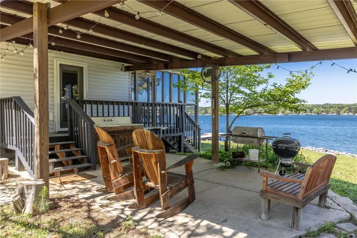 A spacious covered patio invites lakeside relaxation with ample room for grilling and enjoying the water views.