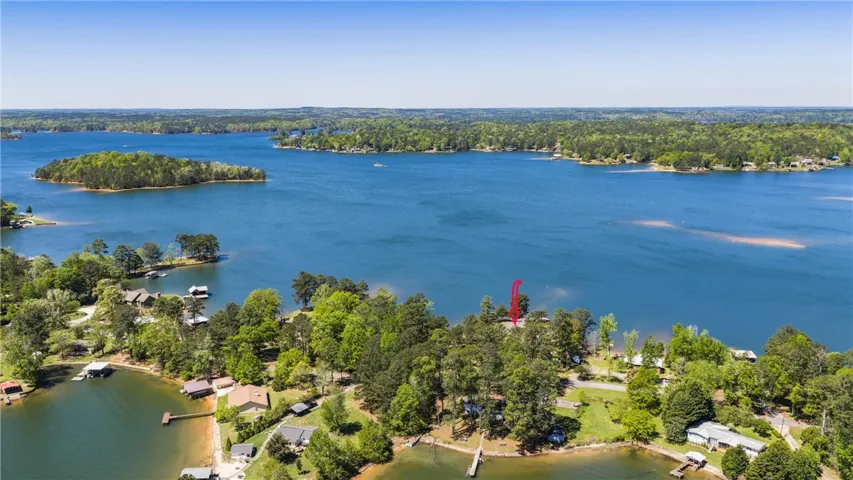 An aerial perspective reveals a serene lake dotted with islands and numerous waterfront properties.