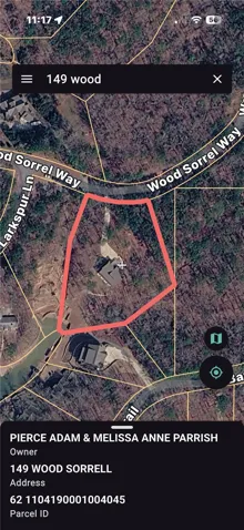 An aerial view showcases a residential property nestled within a wooded landscape.