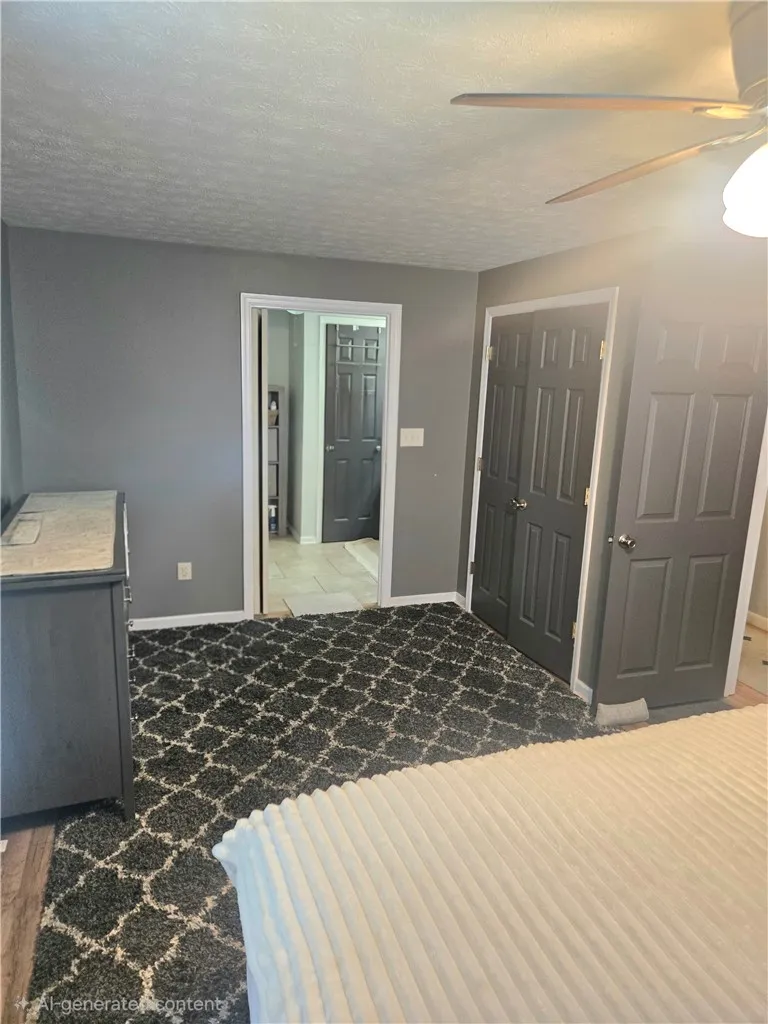 A well-lit bedroom features plush patterned carpeting and direct access to an adjoining space.