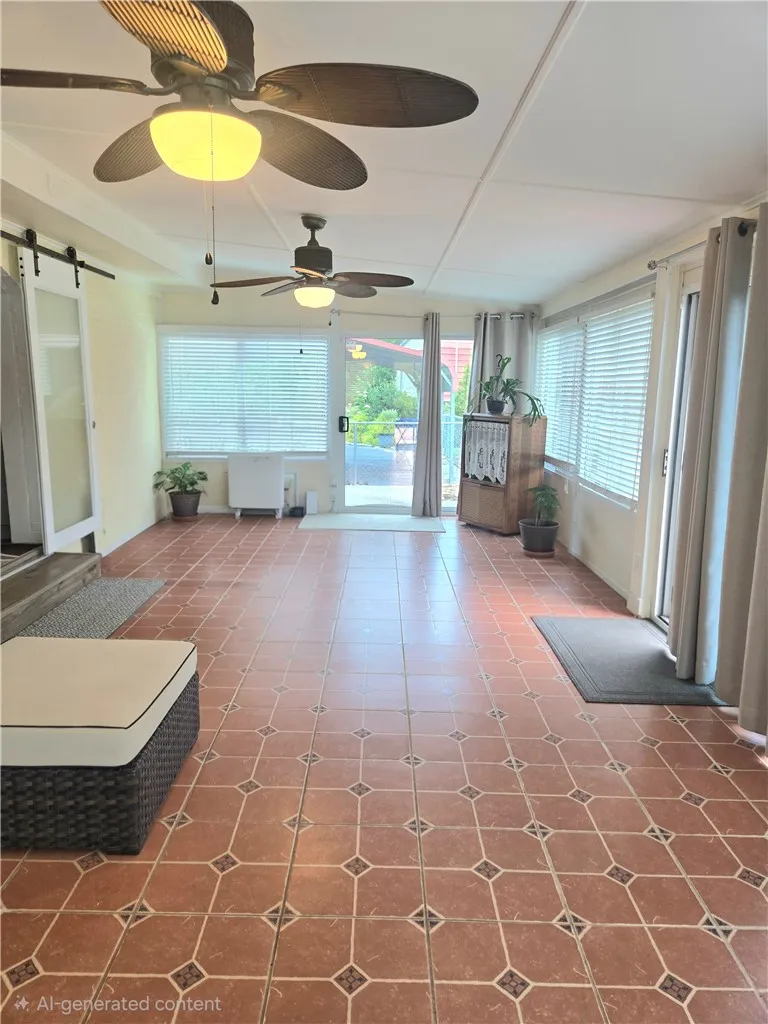 An inviting sunroom with patterned tile flooring and dual ceiling fans offers a refreshing indoor-outdoor feel.