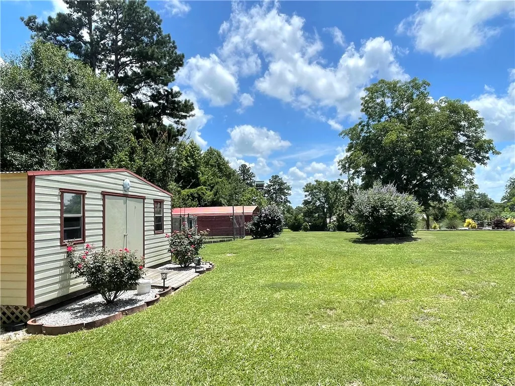 A spacious yard awaits, complete with a functional shed and mature shade trees.