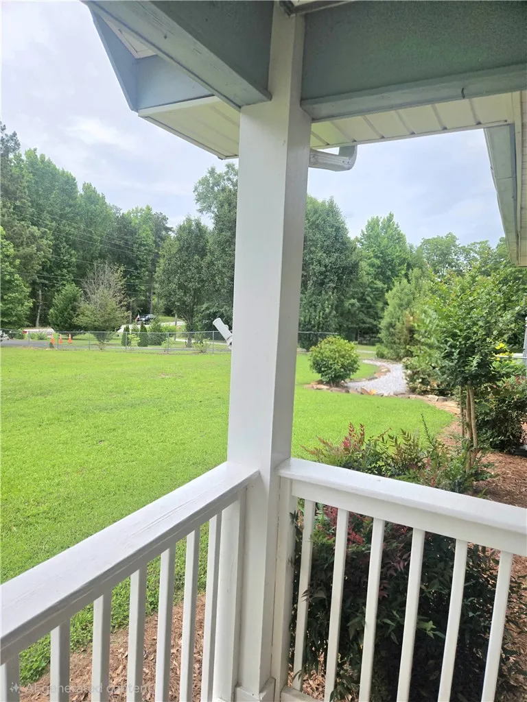 Relax on the inviting porch overlooking a spacious yard and lush green landscaping.