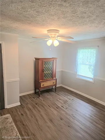 A well-lit room showcasing rich flooring and a convenient ceiling fan.