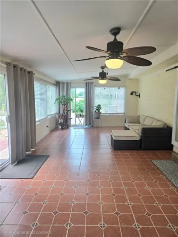 Sun-filled Florida room offers cooling ceiling fans and durable tile flooring for year-round enjoyment.