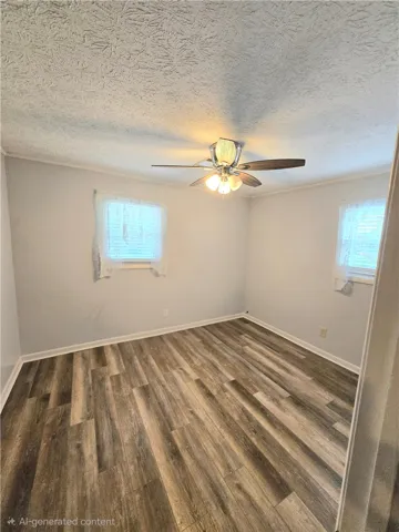 Newly installed wood flooring and a refreshing ceiling fan enhance this cozy sleeping space.