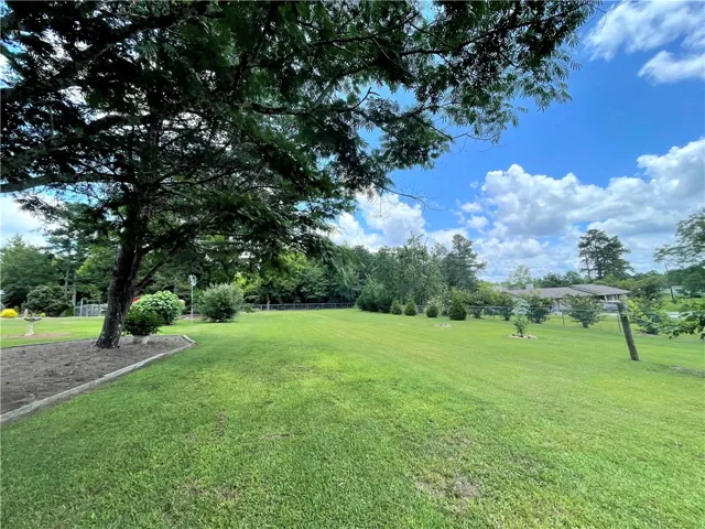 Vast green lawn offers abundant space for outdoor activities and gardening pursuits.