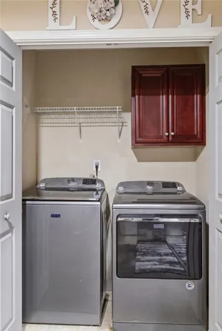 A dedicated laundry closet with ample storage and modern appliances simplifies household tasks.