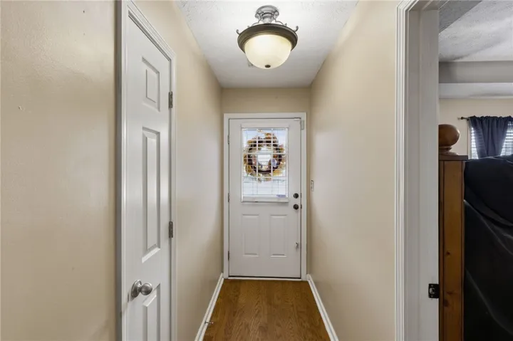 A welcoming entryway with gleaming wood floors and a light-filled door beckons you inside.