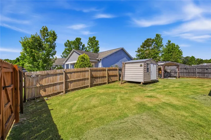 A fully fenced backyard offers a secure and private green space with a convenient storage shed.