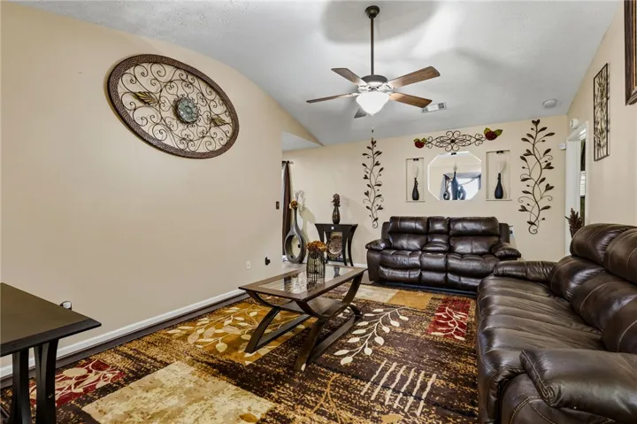 An inviting living area with vaulted ceilings and a warm, richly patterned rug anchors the room.