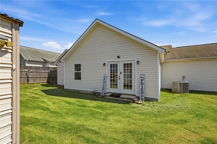 A well-maintained yard provides ample space for recreation, complemented by a charming side entrance.