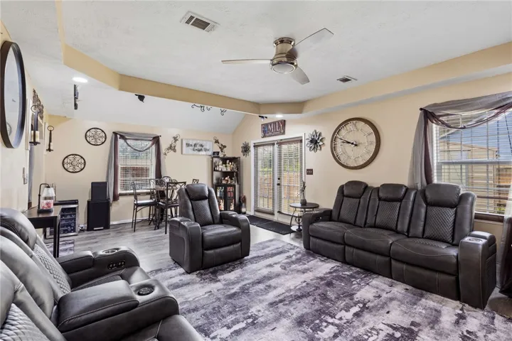 Enter into a comfortable living room featuring a vaulted ceiling and direct outdoor access.