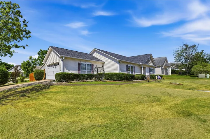 A well-maintained facade with neat landscaping and an attached garage awaits.