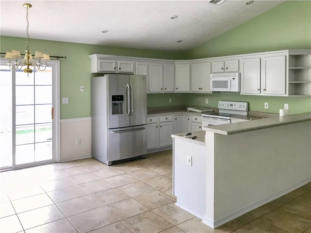 A cheerful kitchen space features a practical breakfast bar and sliding door access to the outdoors.