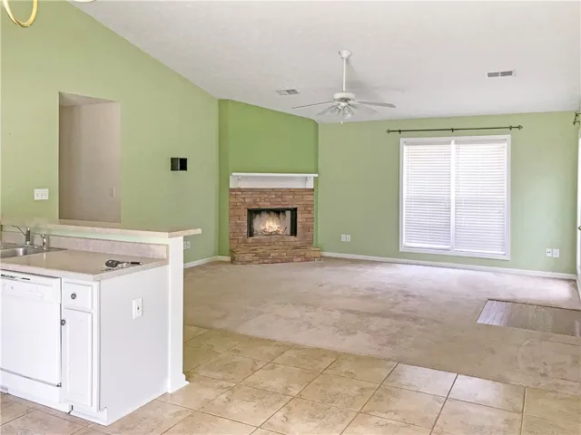 A well-lit living area features a warm fireplace and spacious floor plan.