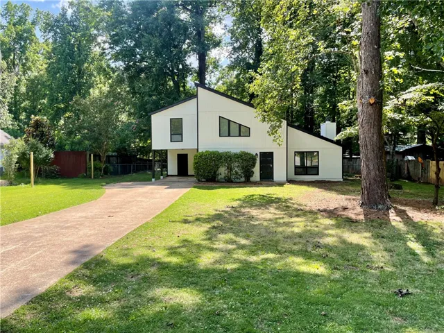 A modern architectural marvel nestled among lush trees, offering a private, verdant setting.