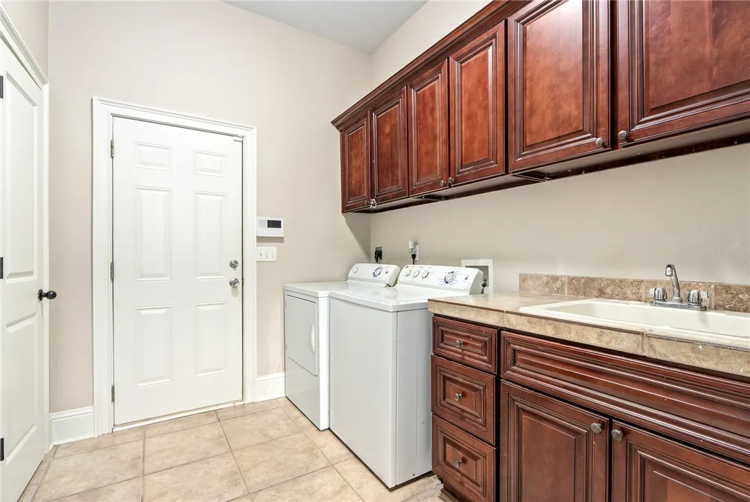 Ample storage cabinetry and practical laundry sink define this functional utility space.