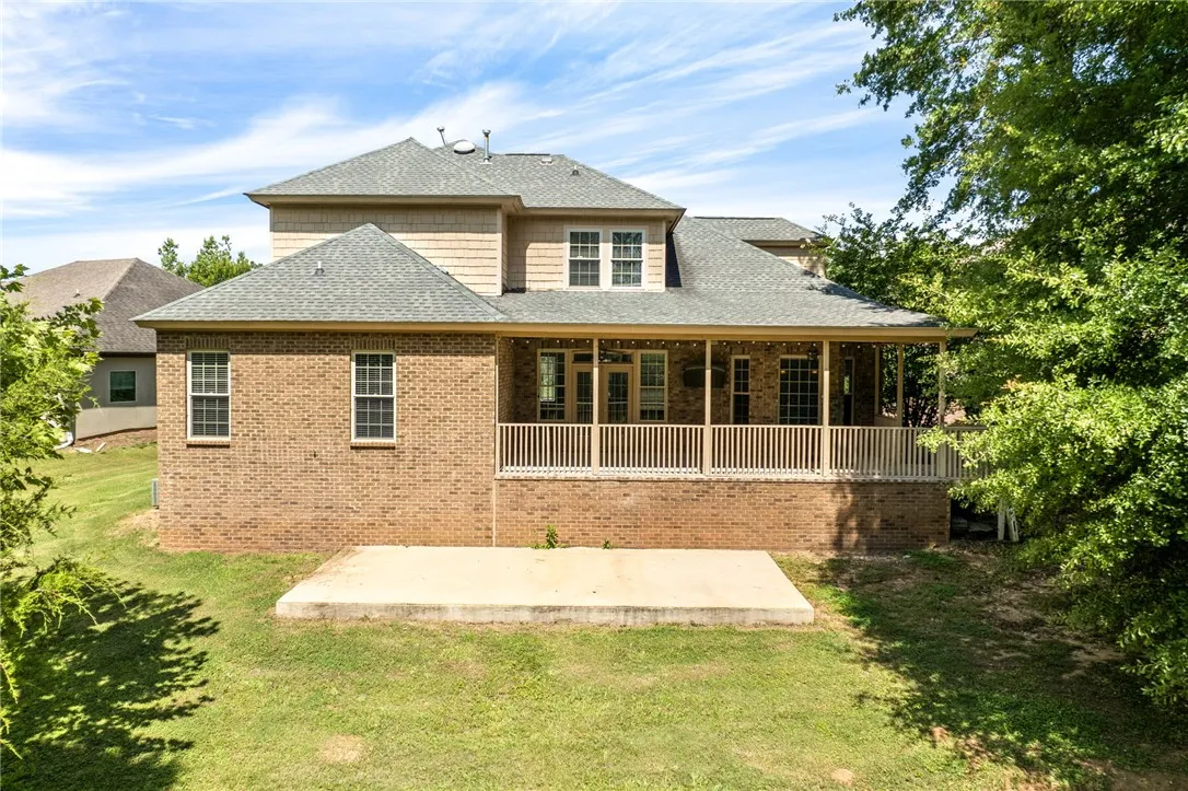 A spacious brick residence with an inviting rear porch, perfect for enjoying outdoor moments.