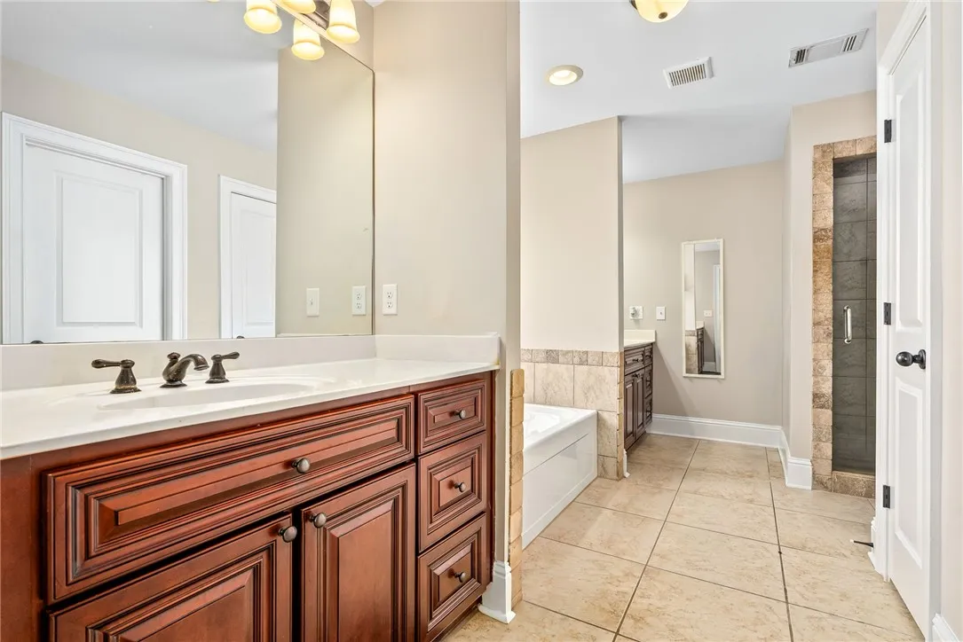 Indulge in a primary bathroom featuring a spacious dual vanity, separate tub, and walk-in shower.
