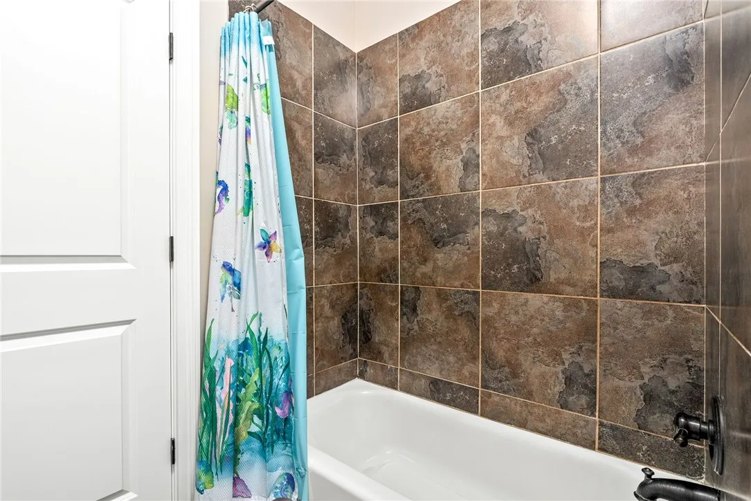 Bathtub and tiled surround offer a tranquil space for unwinding.