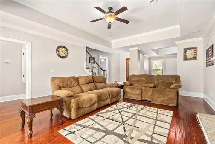 Rich hardwood floors complement detailed crown molding in this inviting living space.