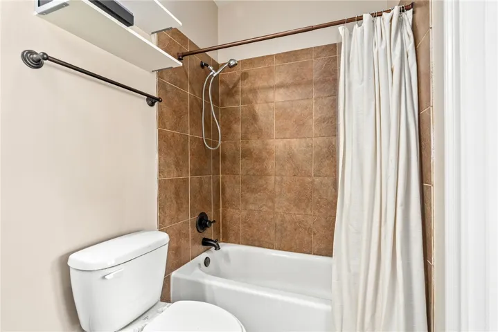 Well-appointed bathroom features a bathtub with shower and tiled surround, providing a comfortable space.