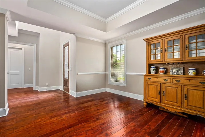 Elegant crown molding accentuates the richly colored hardwood flooring in this welcoming entry space.