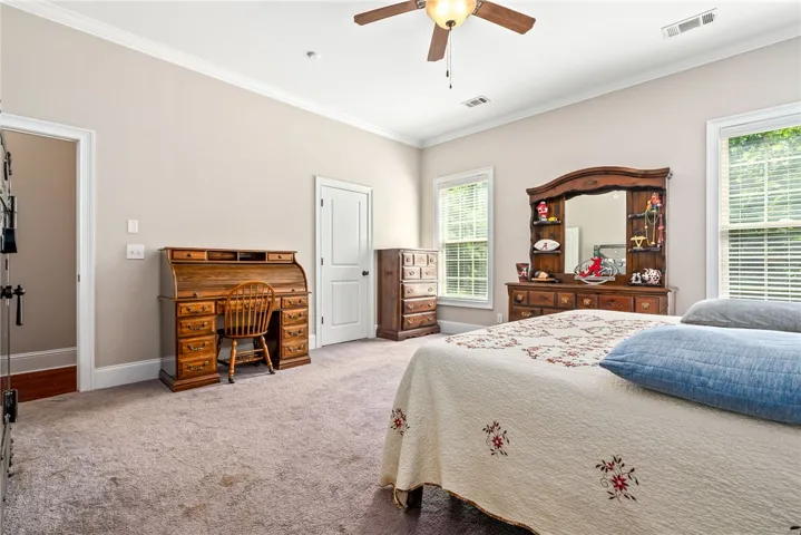 Relax in this comfortable bedroom featuring a warm carpeted floor and ample natural light.