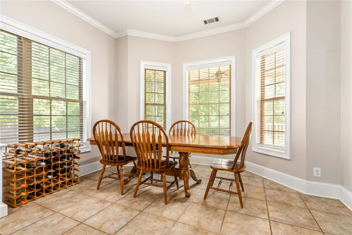 A naturally illuminated dining area boasts ample windows and practical tile flooring.