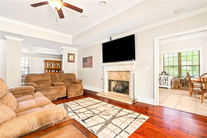 Elegant crown molding accents this inviting living area featuring a cozy fireplace.
