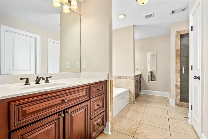 Indulge in a primary bathroom featuring a spacious dual vanity, separate tub, and walk-in shower.