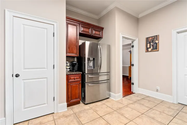 A well-appointed kitchen nook featuring rich cabinetry, a modern refrigerator, and ample space.