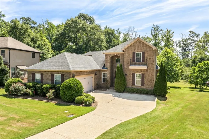 A well-maintained lawn and mature landscaping enhance this traditional brick residence.