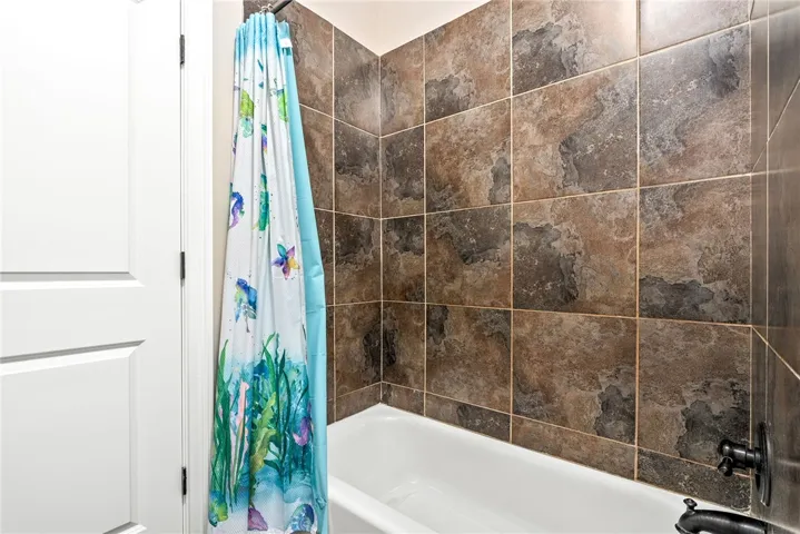 Bathtub and tiled surround offer a tranquil space for unwinding.