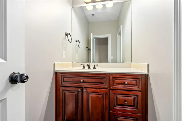 A well-appointed bathroom vanity with a spacious mirror and rich wooden cabinetry.