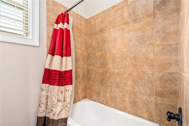 A window-lit bath with a tiled surround offers a refreshing start to your day.