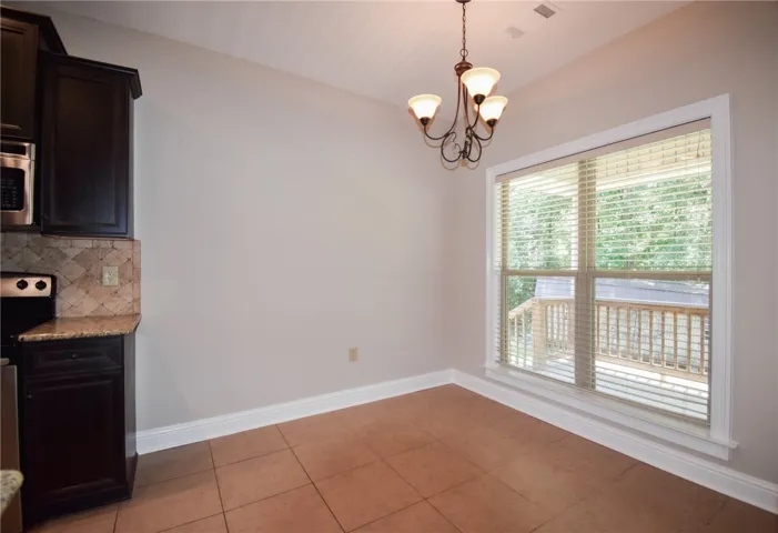A well-lit dining area offers direct access to the outdoor deck, perfect for casual meals.