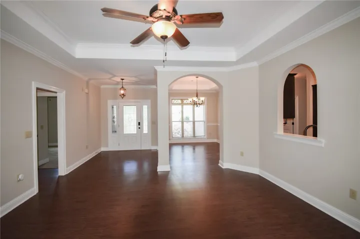 A welcoming entryway with rich wood flooring leads to a spacious, open floor plan.