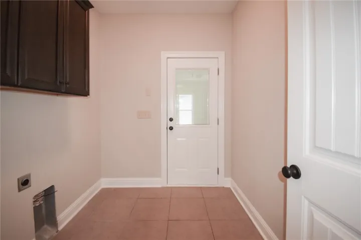 Functional utility space with durable tile flooring and convenient exterior access.