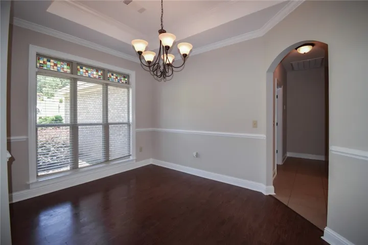 A graceful dining area, enhanced by tray ceilings and rich wood flooring, awaits memorable gatherings.