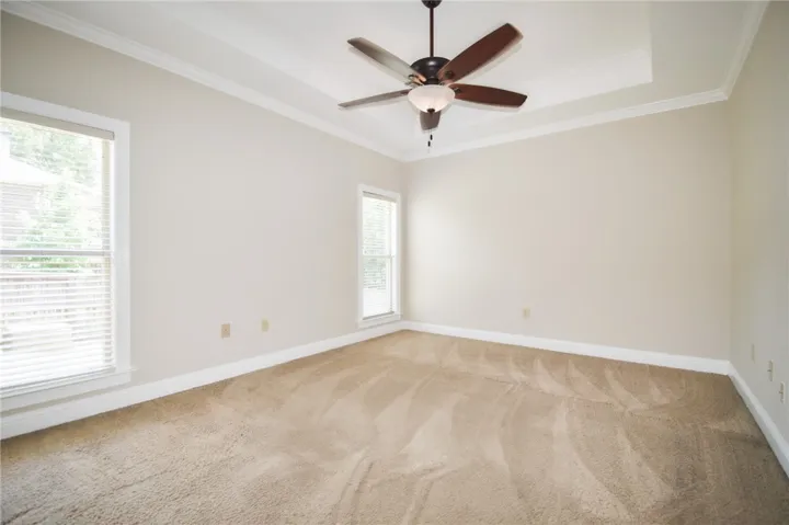 A quiet retreat with a classic ceiling fan and plush carpet, ready for personalization.
