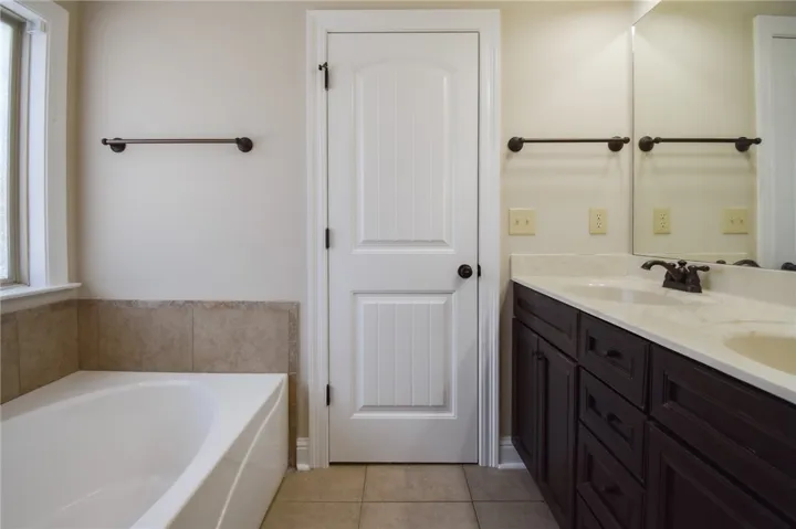 Double vanity and a deep soaking tub await in this well-appointed bathroom.