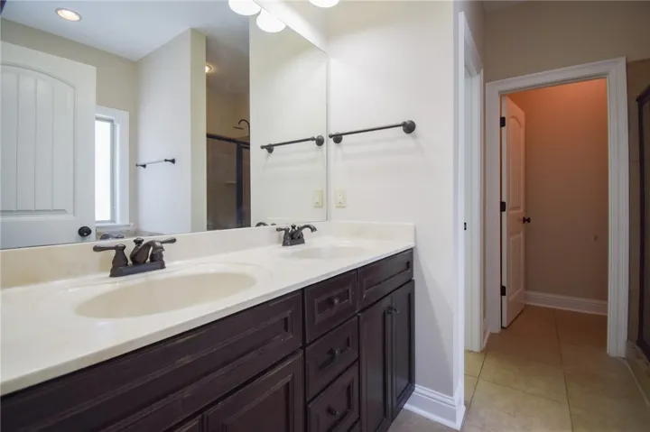 A well-appointed primary bathroom features a dual vanity with ample storage, providing both style and convenience.