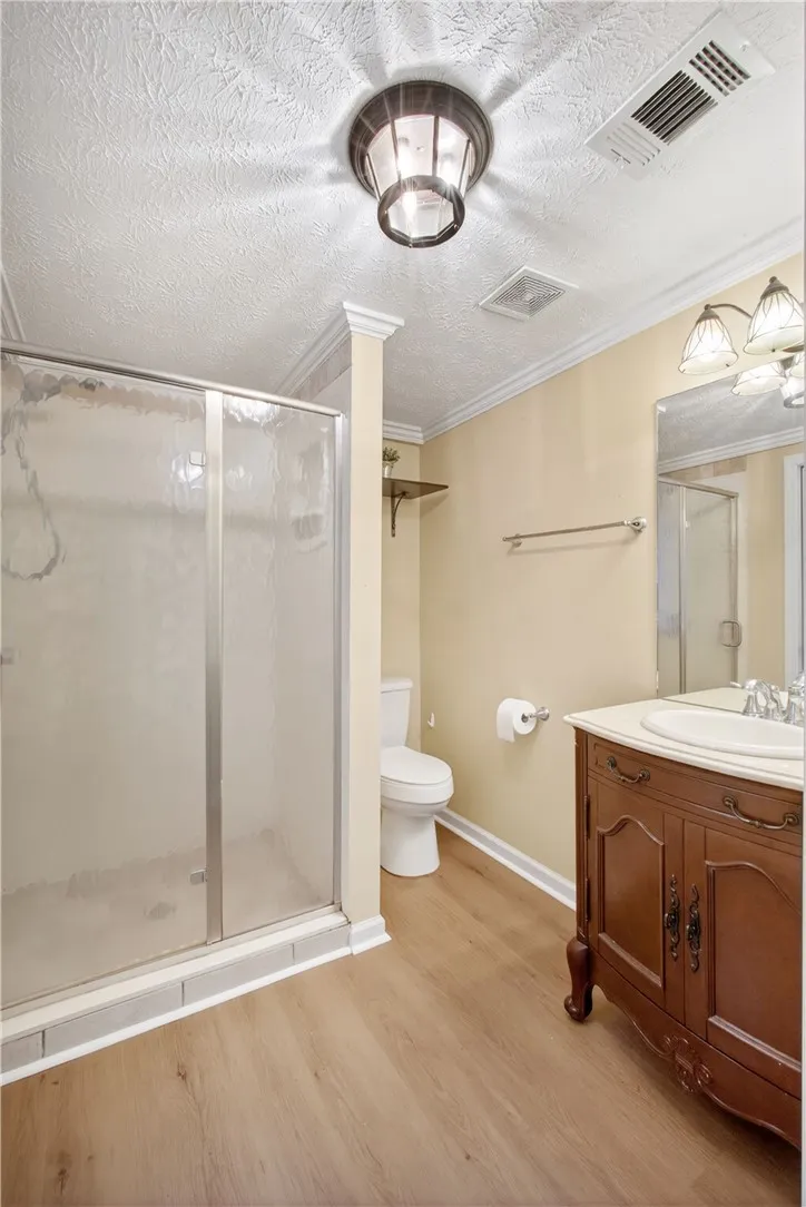 A well-appointed bathroom features a glass-enclosed shower and a vanity with a polished sink.