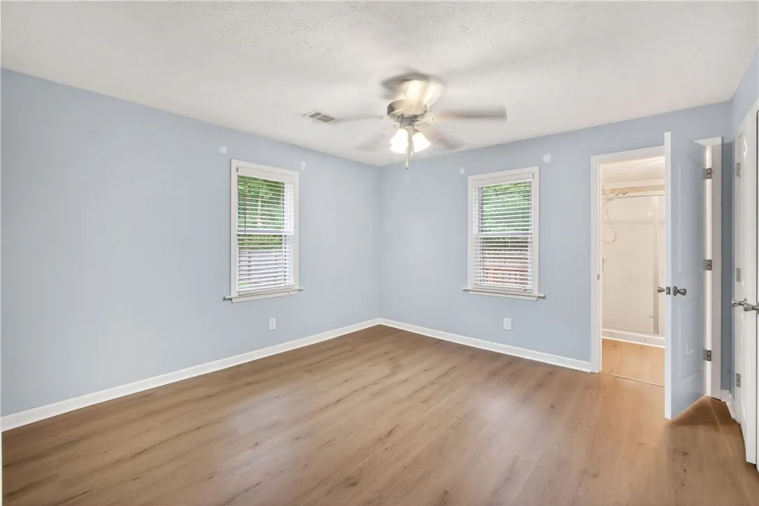 A well-lit bedroom features durable laminate flooring and an inviting ambiance.