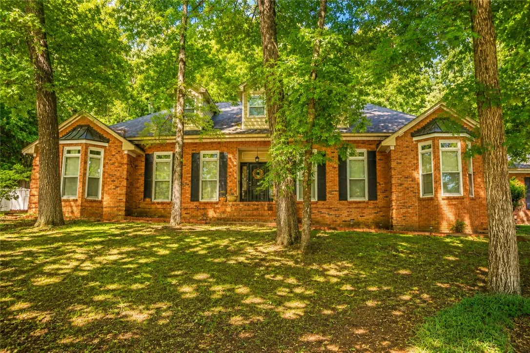Mature trees frame this traditional brick residence, offering ample curb appeal and natural shade.